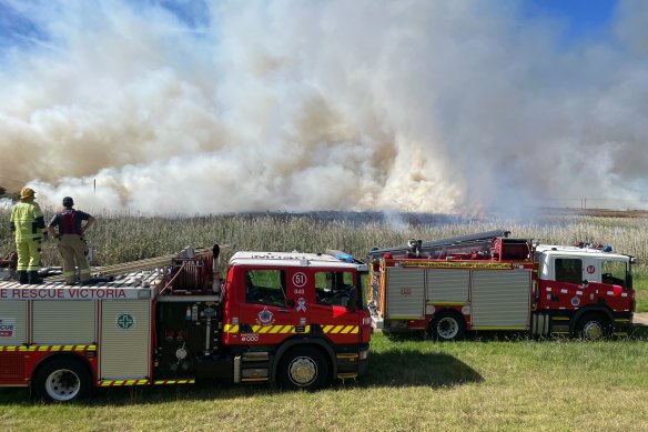 Fire crews work to contain an Altona grass fire on Monday.