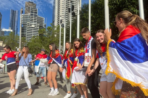 Djokovic fans celebrate outside the court building.