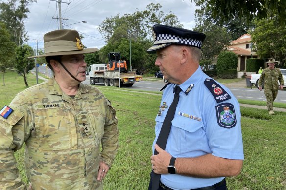 Major-General David Thomae, commander of the flood recovery taskforce, speaks with Queensland Police Deputy Commissioner Shane Chelepy in St Lucia on Saturday.