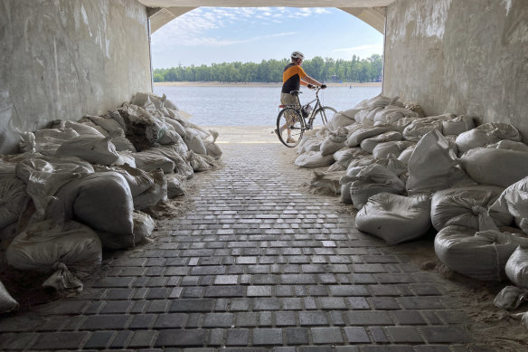 A Sunday morning cyclist emerges from a sandbagged tunnel next to the Dnipro River in Kyiv, Ukraine, earlier this month. Britain says Russia has troops stationed near the river close to the city of Kherson.