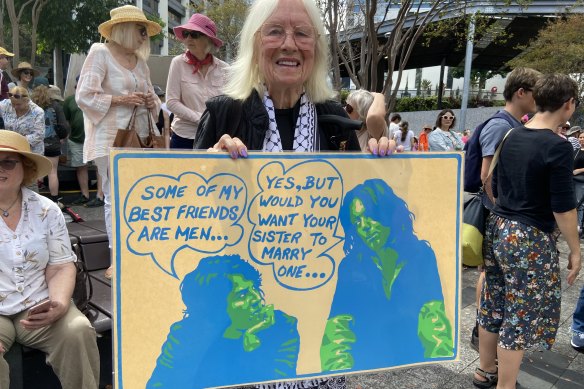Long-serving University of Queensland women’s studies Professor Carole Ferrier with a 1960s poster which she said demonstrated how long women’s issues, including male violence, have been debated.