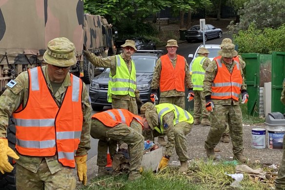 Army personnel help clean up St Lucia on Saturday following the floods.