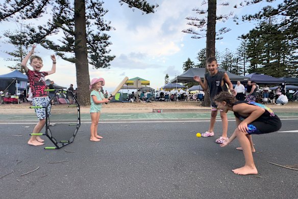 Kids playing street cricket at Dee Why Beach.