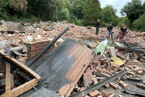 People inspect the rubble remains of The Crooked House pub in Himley, near Dudley in the West Midlands, which has been demolished two days after it was gutted by fire.