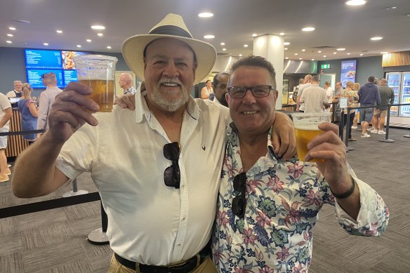 Father-of-the-groom Paul Lock, left, and father of the bride  Kev Kelly enjoy the MRC’s new beer prices at Sandown. 