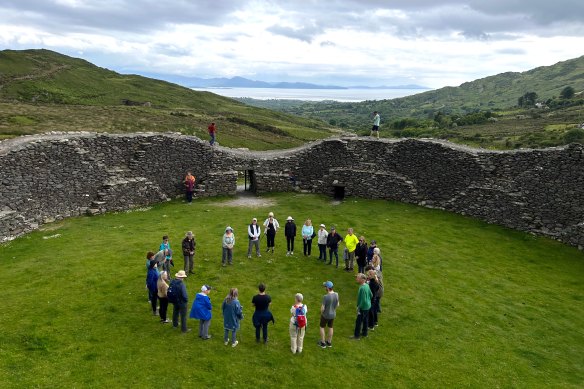 Nóirín Ní Riain (in foreground, long denim jacket and white shoes) sings a Gregorian chant to visitors at the Staigue Stone Fort, said to date back to the Iron Age.