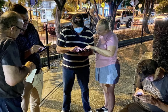 Eliza Williams (in pink shirt) helping people navigate the border pass application form.