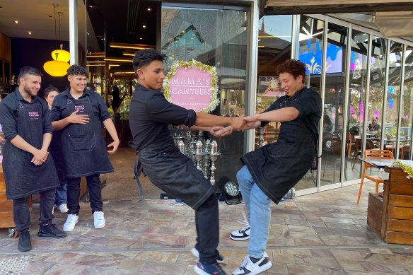 Staff at Mama’s canteen dancing as they prepare for their customers.