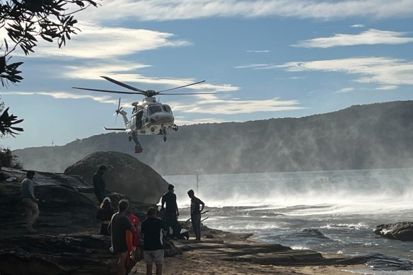 A helicopter arrives at Flint and Steel Beach in Ku-ring-gai Chase National Park on Saturday. 