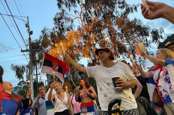 Novak Djokovic supporters light candles and sing in Serbian outside the Park Hotel in Melbourne.