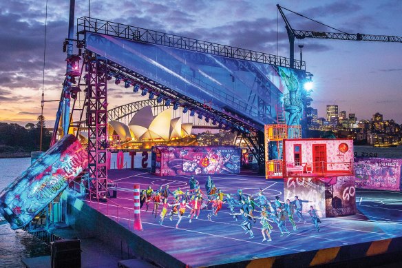 The musical takes place on an overwater harbour stage framed by Sydney’s glittering high-rises.