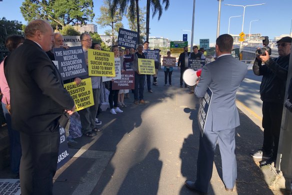 Katter’s Australian Party MP Nick Dametto speaks to protesters outside the Queensland Parliament, while fellow KAP member Shane Knuth watches on.
