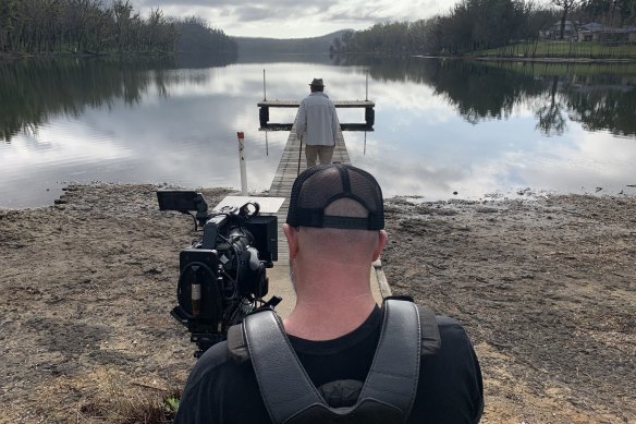 Brennan (in front) films poet Stephen Chinnock on Lake Conjola, making his film We are Conjola.