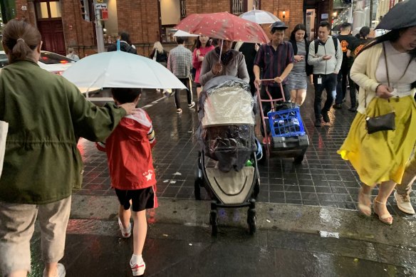 Drenched: Commuters in Sydney on Friday evening.