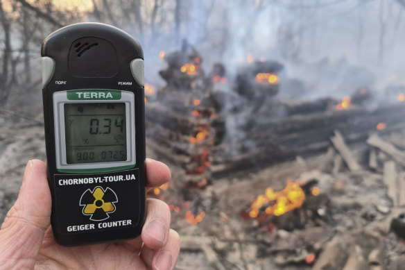 A Geiger counter shows increased radiation level against the background of the forest fire burning near the village of Volodymyrivka in the exclusion zone around the Chernobyl nuclear power plant, Ukraine.