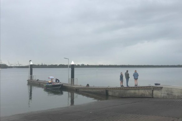 A group of people wait at the Port of Brisbane for dozens of boats searching for Trent Riley to return with good news.