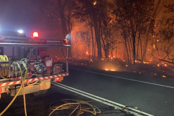 Fire crews battle a bushfire threatening homes near Batemans Bay. 