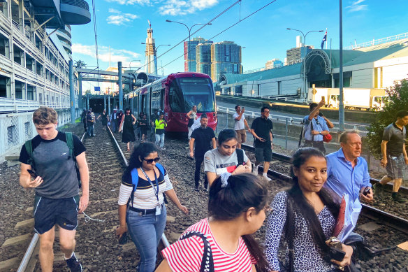 Passengers being evacuated on foot at Exhibition station after a power failure on the light rail, 25 February 2020.