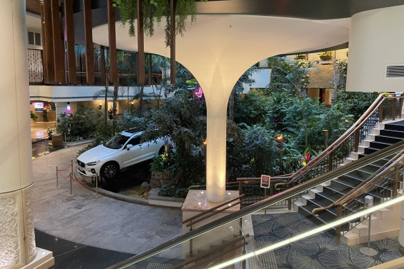 An $87,000 Volvo, a prize in a lottery, sits among fake greenery in the atrium.