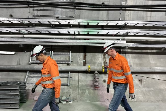 Cross River Rail Delivery Authority chief executive Graeme Newton and Transport Minister Mark Bailey walk past some of the hundreds of kilometres of cabling laid deep underground.