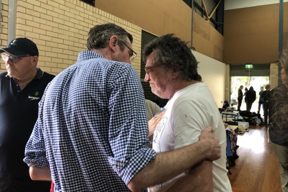 Lismore resident Ian Lyle is comforted by Premier Dominic Perrottet.