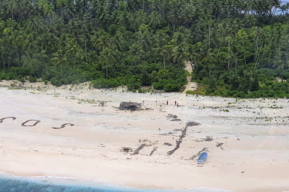 Three men are spotted on the beach on Pikelot Island.