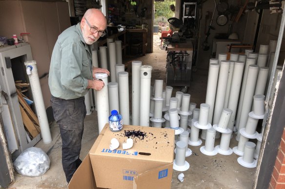 Mike Saxon, head of the environment department's biodiversity and conservation unit for south-east NSW, with the feeders built during a 'working bee' at his garage in Canberra.
