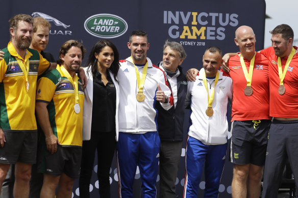 Prince Harry and Meghan, Duchess of Sussex pose for a photograph with medal winners at the Invictus Games driving challenge on Cockatoo Island in Sydney,  Saturday, October 20, 2018. 