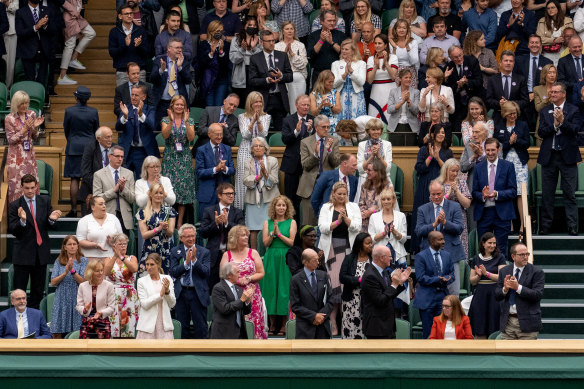 Spectators in the royal box stand for Oxford Professor Sarah Gilbert (seated in red, bottom right), one of the people behind the AstraZeneca COVID-19 vaccine ahead of the opening match on day 1 of The Championships - Wimbledon 2021.