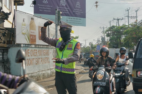 A traffic policeman attempts to unravel a build-up of vehicles in Canggu.