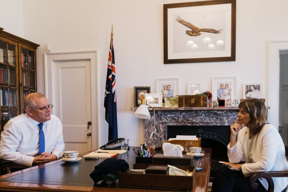 Morrison in his office with senior writer Deborah Snow and the  eagle image, a divine signal, he says, he needed to persevere.