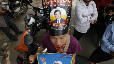 A supporter of the opposition Cambodia National Rescue Party, wears party president Kem Sokha portrait poster reading"Free" as she stands outside the Supreme Court in Phnom Penh, Cambodia in October.  Kem Sokha was targeted by a wave of misinformation on social media, before being jailed for alleged 'treason.' 