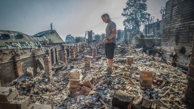 John Blankenstein amid the ruins of the Tathra home of his parents-in-law.