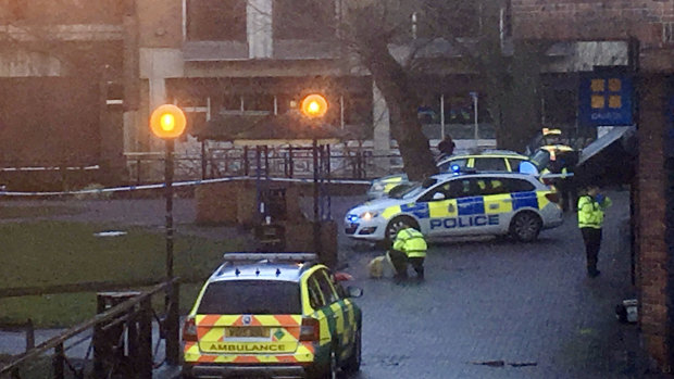 A police officer without protective gear crouches down  next to the bench at the shopping centre where Sergei Skripal and his daughter Yulia were found on Sunday.