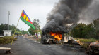 A Kanak flag waving next to a burning vehicle at a roadblock at La Tamoa, in the commune of Paita in New Caledonia.