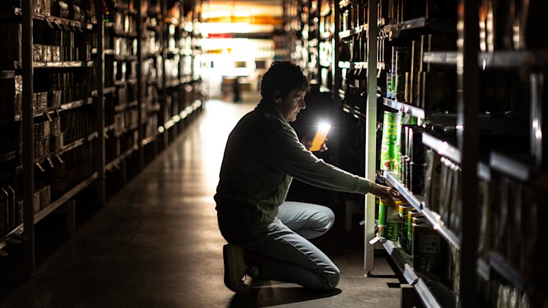 Shoppers grab groceries by torchlight as bushfire leaves Yea in the dark