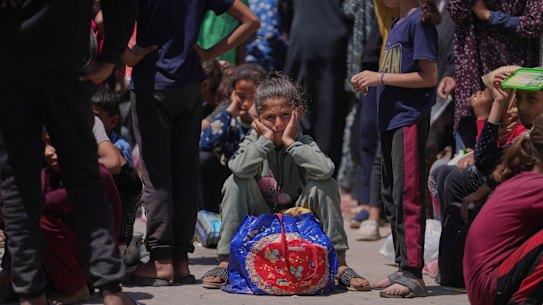 A Palestinian girl waits to collect donated food from a distribution kitchen in Deir al-Balah, Gaza Strip, on Friday.
