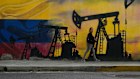 A local walks past a mural featuring oil pumps and wells in Caracas, Venezuela, this week.