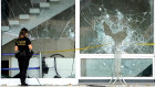 A Federal investigator outside the Brazilian Supreme Court building in front of windows damaged by supporters of Brazil’s former President Jair Bolsonaro.