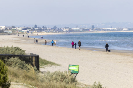 Walkers enjoying a stroll on Aspendale beach.