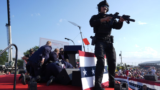 Republican presidential candidate Donald Trump is covered by Secret Service agents at a campaign rally on Saturday evening local time.