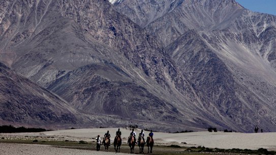 Tourists ride double hump camels at Nubra valley, in Ladakh, India - the scene of a stand off between nuclear powers India and China.