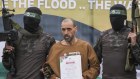 Israeli captive, Eli Sharabi, who has been held hostage by Hamas in Gaza since October 7, 2023, stands on a stage escorted by Hamas fighters before being handed over to the Red Cross.