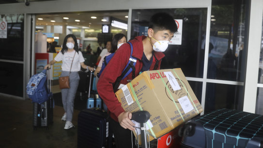 People arriving at Sydney Airport wearing masks.