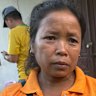 Mun Duang Somdi holding a picture of her son who has been found alive in the cave in Laos.