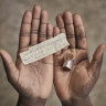 A Mauritanian migrant who crossed the US southern border shows the address of a Manhattan shelter he kept in the compartment of a ring during his journey.