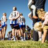 The Thornton Eildon Football Club players listen to the pre game address by coach Tash Hay as team members children play. Jamee Cousens looks after the kids, so her sister Bechet can play. The Thornton Shinboners are the only all female club in Victoria with no mens teams.