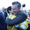 Jockey Craig Williams hugs trainer Adrian Bott.