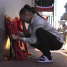 A woman places flowers at a memorial at the scene of this week’s attack in New Orleans.