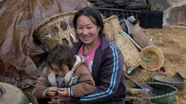 Xu Xuanhua, 31, the mother of three children embraces her 3-year old son Xia Zhongshuia in Xuanqiao Village, Zhaotong City of Yunnan Province in November